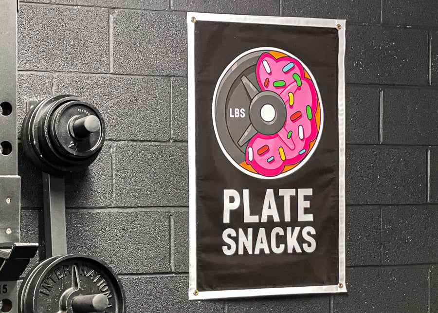 Plate Snacks logo banner hanging on black gym wall